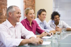 Four businesspeople in boardroom smiling