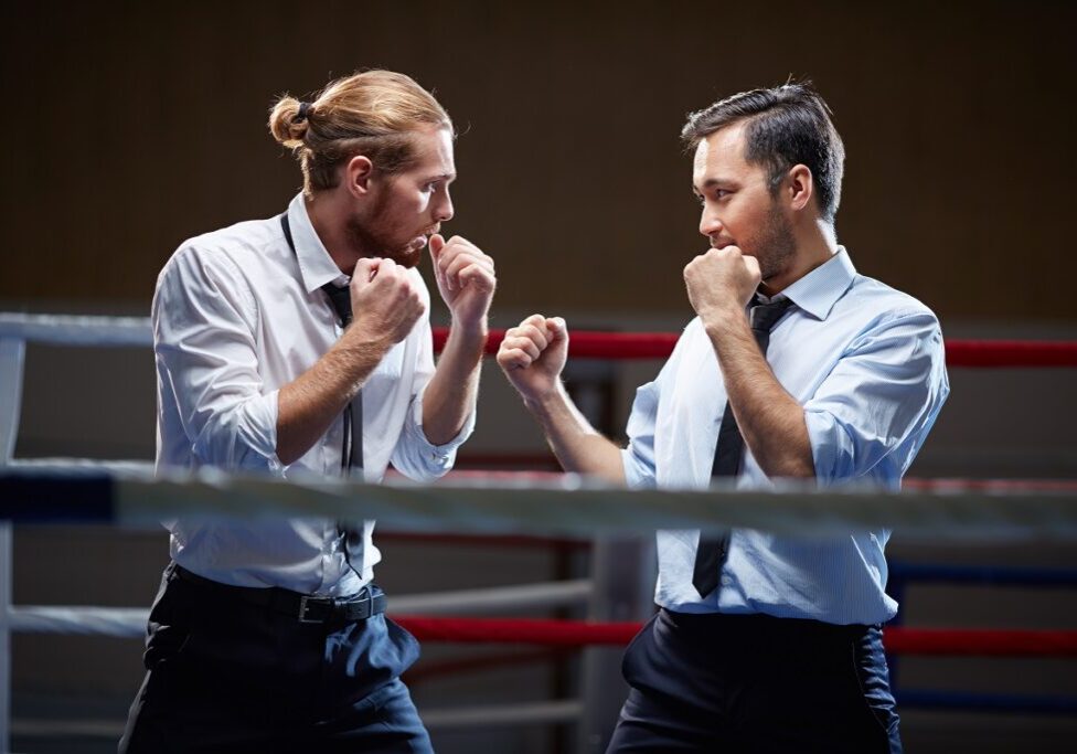 Businessmen fighting with one another on boxing ring